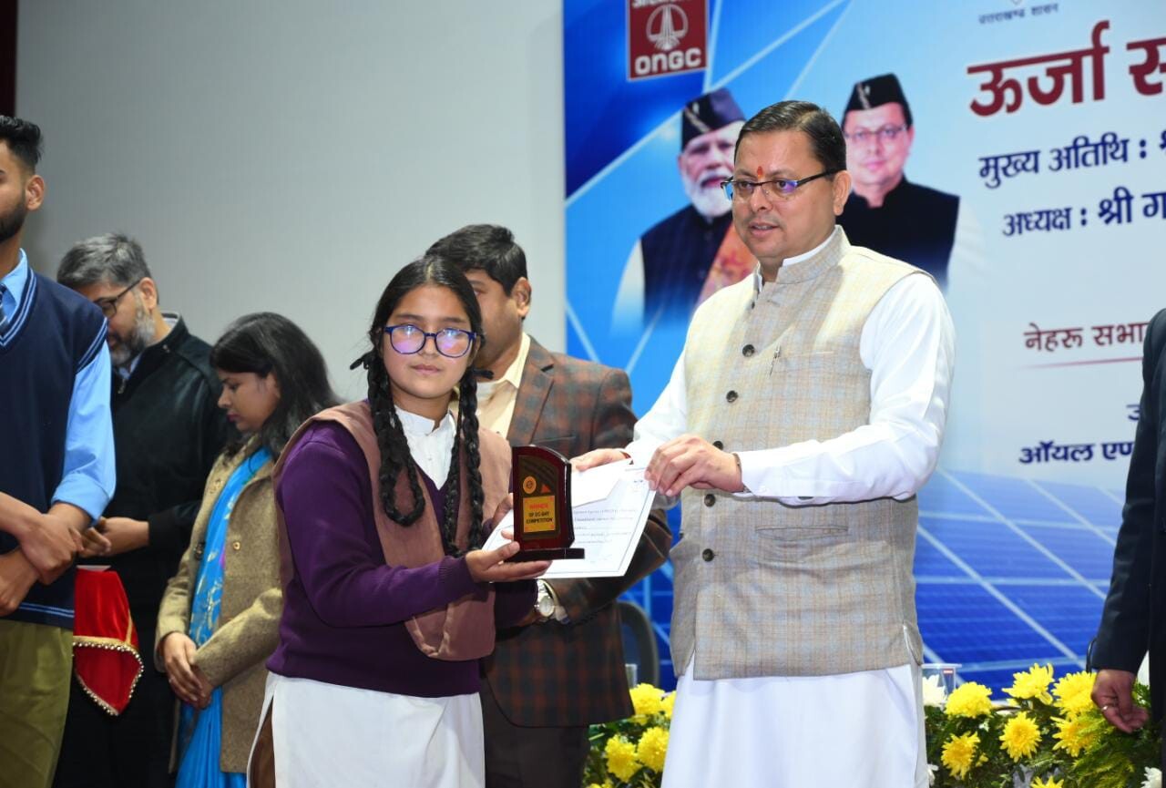 Pushkar Singh Dhami giving award to a girl
